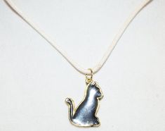 Gold Tone Metal Pendant Black Cat Kitten Pendant White Corded Necklace Cat is  is 1 1/8 inches x 3/4 inches Black Cat Kitten, Vampire Jewelry, Corded Necklace, Remembrance Necklaces, Vial Necklace, Necklace Cat, Acorn Necklace, Science Jewelry, Tube Necklace