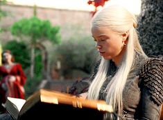 a woman with long white hair sitting on a bench