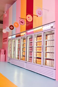 an ice cream display in a brightly colored room with pink, yellow and orange walls