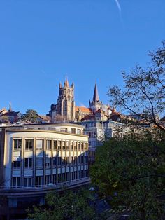 an old building with steeples and spires stands in front of the city skyline