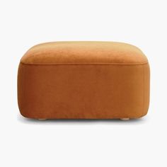 the foot stool is made from an orange colored material and has wooden legs, with a rounded