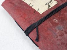 an old red book with black string tied to it