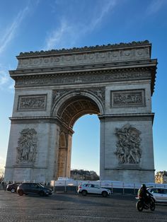 cars are parked in front of the arc de trioe, which is located on the champs