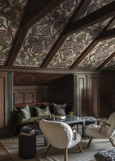 a living room filled with furniture and walls covered in intricately designed wood paneling