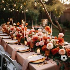 an outdoor dinner table with candles and flowers