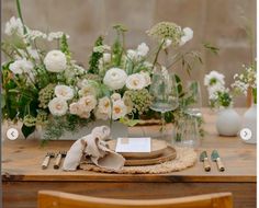 a wooden table topped with lots of white flowers