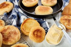 some breads and butter on a table next to a pan with other food items