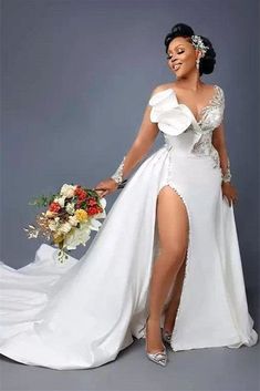 a woman in a white wedding dress holding a bouquet and posing for the camera with her leg high