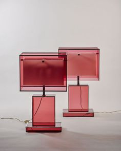 three pink lamps sitting next to each other on top of a table