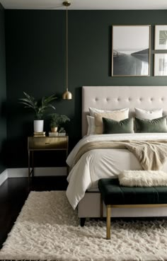 a bedroom with dark green walls and white bedding, rugs and pictures on the wall