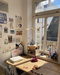 a room with a wooden table and lots of magnets on the wall next to a window