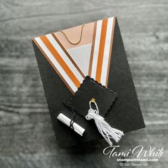 an orange and white graduation cap with a tassel on it's end piece