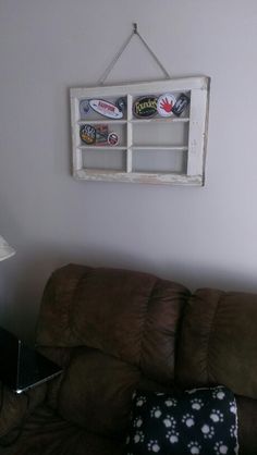 a living room with a brown couch and a white window hanging on the wall above it