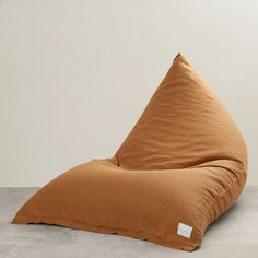 a large bean bag chair sitting on top of a cement floor next to a wall