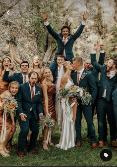 a group of people standing next to each other with their arms in the air and holding flowers