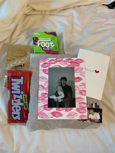 the contents of a diaper laid out on top of a bed with an adult and child's photo