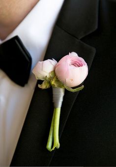 a boutonniere with pink flowers on the lapel of a man in a tuxedo