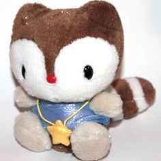 a brown and white stuffed animal wearing a blue shirt with gold stars on it's chest