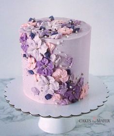 a white cake with pink and purple flowers on it