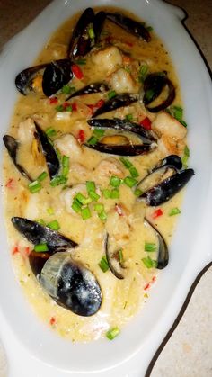 a white plate topped with seafood and rice