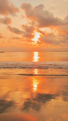 the sun is setting over the ocean with clouds in the sky