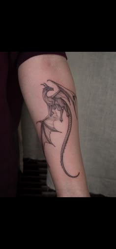 a woman's arm with a dragon tattoo on the left side of her leg