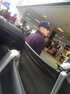 a man sitting in an airport waiting for his luggage