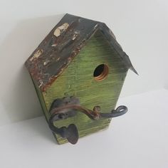 a wooden birdhouse with an iron handle on it