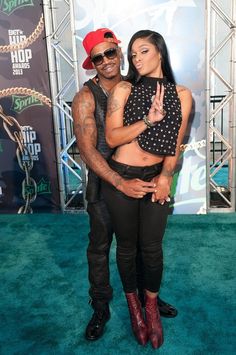 a man and woman posing on the green carpet