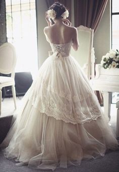 a woman in a wedding dress looking out the window