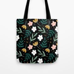 a black tote bag with flowers and leaves on it