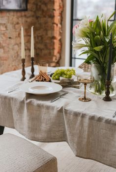 a table set with plates, candles and flowers