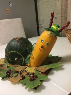 a decorative vegetable sitting on top of leaves next to a pumpkin and gourd