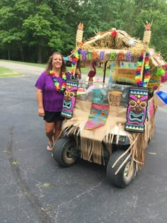 a woman standing in front of a cart with decorations on the back and sides,