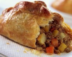 a close up of a pastry with meat and vegetables