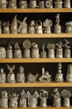 a shelf filled with lots of silver items on top of wooden shelves next to each other