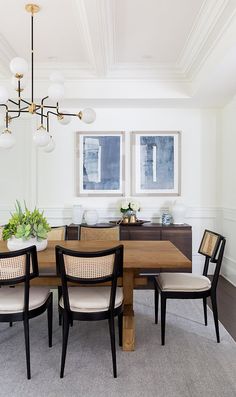 a dining room table with four chairs and a chandelier hanging from the ceiling