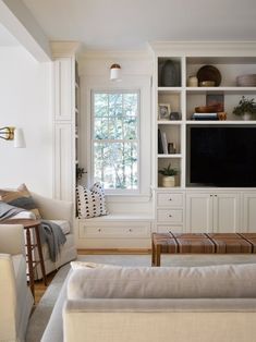 a living room filled with furniture and a flat screen tv mounted on a wall next to a window