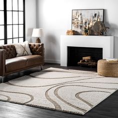 a living room area with a couch, chair and rug in front of a fireplace