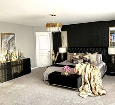 a bedroom decorated in black and gold with fur on the bed