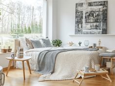 a bedroom with white walls, wooden floors and a bed in the middle of it