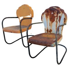 two rusty chairs sitting next to each other