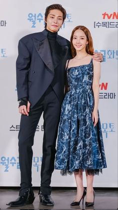 two people standing next to each other on a red carpet