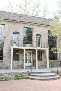 an old brick house with stone steps leading up to the front door and second story