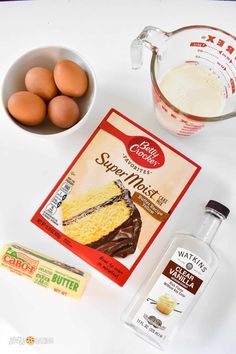 ingredients to make chocolate cake sitting on a counter next to eggs, butter and milk