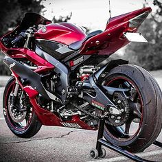 a red motorcycle parked on top of a parking lot