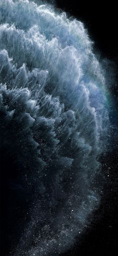 an ocean wave is shown in the dark sky with water splashing on it's side