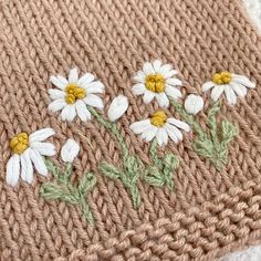 a knitted blanket with daisies on it