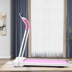 a pink and white treadmill in front of a window