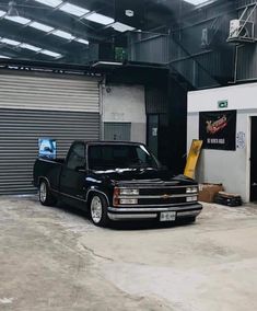 a black truck parked in front of a garage